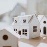 Simple image of a village of white cardboard houses in various shapes and sizes 