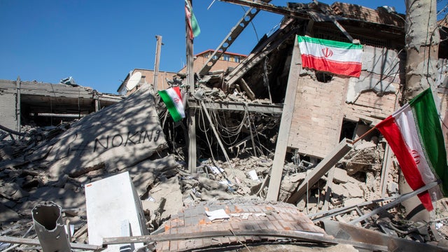 Iranian flags are seen amid debris in Tehran, Iran 