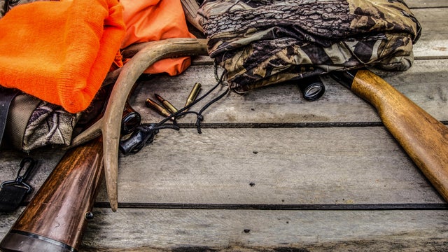 Deer Hunting Gear Background With Rifles, Rattling Antlers, Deer Call And Camouflage 