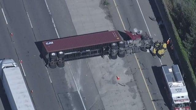 An overturned big rig blocking lanes on a highway 