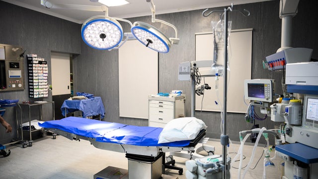 Wide shot empty surgical theatre with operating table 