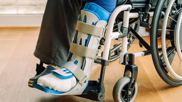 Detail or woman in a wheelchair with leg brace after sport injury 