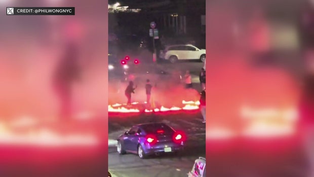 A ring of fire in the middle of an intersection with pedestrians and drivers 