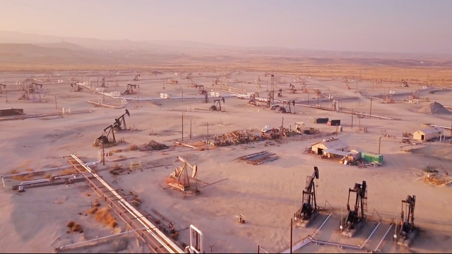Lone pumpjack located in the middle of large solar array outside of Bakersfield 
