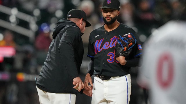 New York Mets pitcher Devin Williams, right, hands the ball to manager Carlos Mendoza as he leaves during the ninth inning of a baseball game against the Minnesota Twins Tuesday, April 21, 2026, in New York. 