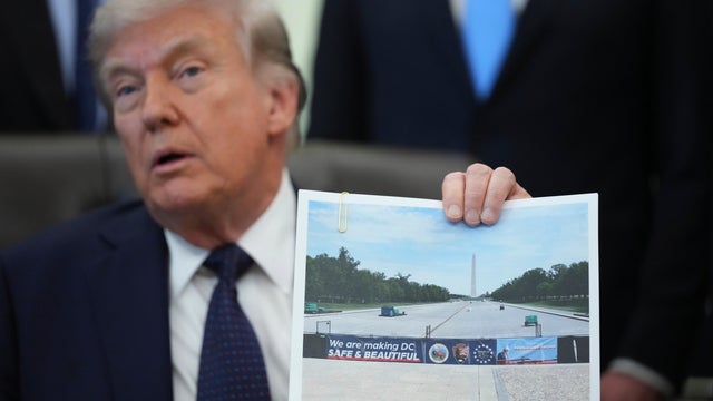 President Trump holds an image of the Lincoln Memorial Reflecting Pool during an event on health care affordability in the Oval Office at the White House, Thursday, April 23, 2026, in Washington. 