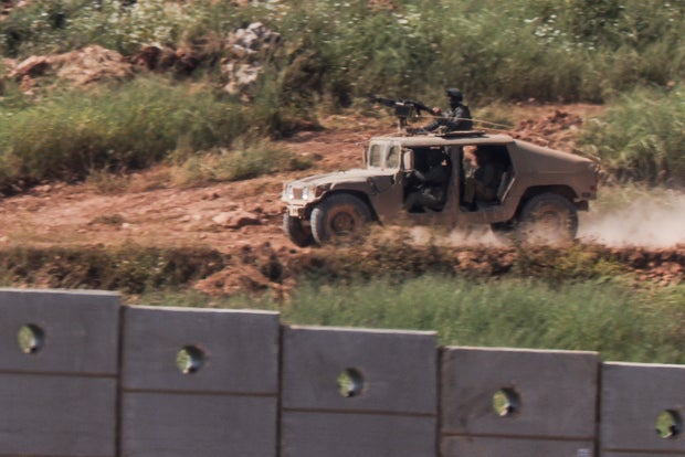 An Israeli armoured vehicle drives inside Lebanon, as seen from the Israeli side of the border with Lebanon 