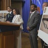 Justice Department officials stand in front of photos of the weapons allegedly carried by Cole Allen, the suspect charged with trying to assassinate President Trump at the White House Correspondents' Dinner. 