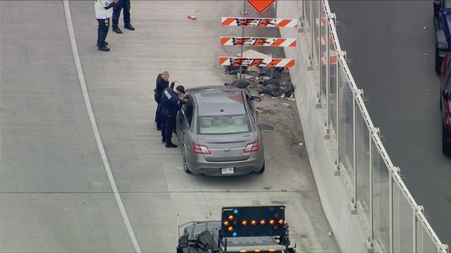 Police look at a car on the shoulder of a 95 ramp 