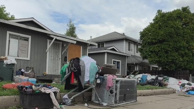 Trash is seen piling up outside of a home 