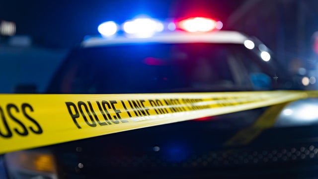 Flashing Lights and Police Tape Reading "Police Line Do Not Cross" 