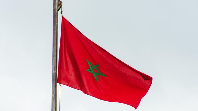 Moroccan flag against cloudy sky 