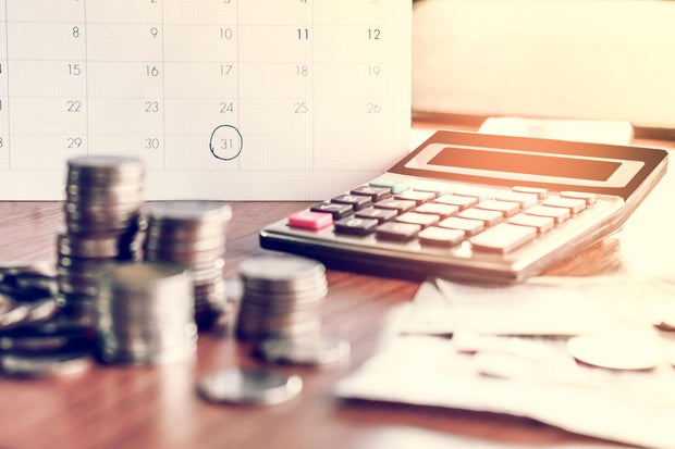 debt collection and tax season concept with deadline calendar remind note,coins,banks,calculator on table 