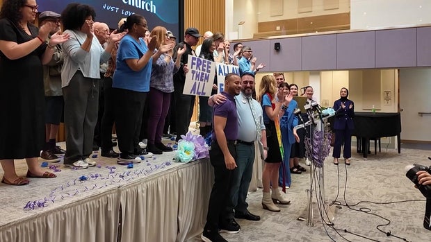 Allan Marrero stands with his husband and members of his church community 