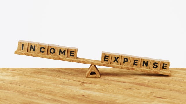 3D income vs expenses on balance scales. Living paycheck to paycheck. High income with low expenses. Financial problems, monthly expenses, inflation, debt or loan concept 