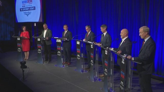 multiple people standing on a stage with podiums 