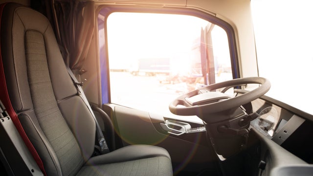 Truck vehicle interior with driver seat and steering wheel. Truck drivers wanted. Professional drivers job opening and career. 