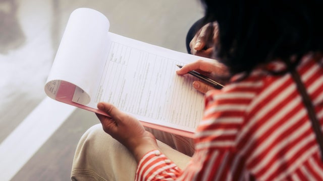 Over the shoulder view of woman filling medical form 