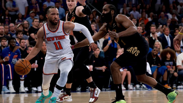 Jalen Brunson #11 of the New York Knicks drives around James Harden #1 and Sam Merrill #5 of the Cleveland Cavaliers during the fourth quarter in Game One of the NBA Eastern Conference Finals at Madison Square Garden on May 19, 2026 in New York City. 