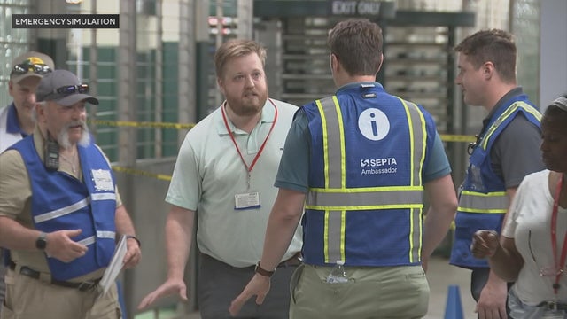 SEPTA workers participate in a safety drill at the Walnut Locust subway station, they are wearing vests and talking into walkie talkies 