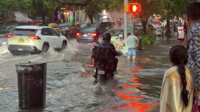 Cars drive through floodwaters on Long Island Expressway 