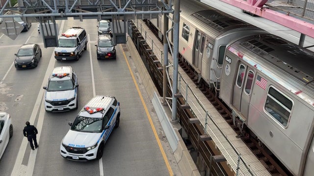 NYPD vehicles alongside subway train on Williamsburg Bridge 