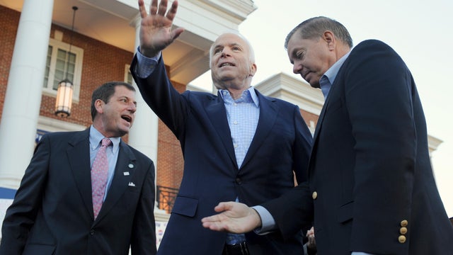 John McCain, pictured with his son Douglas McCain and Sen. Lindsey Graham, waves during a campaign rally on Nov. 1, 2008. 