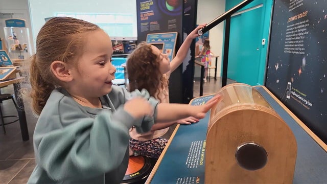 A girl plays with something at the Delaware Museum of Nature and Science 