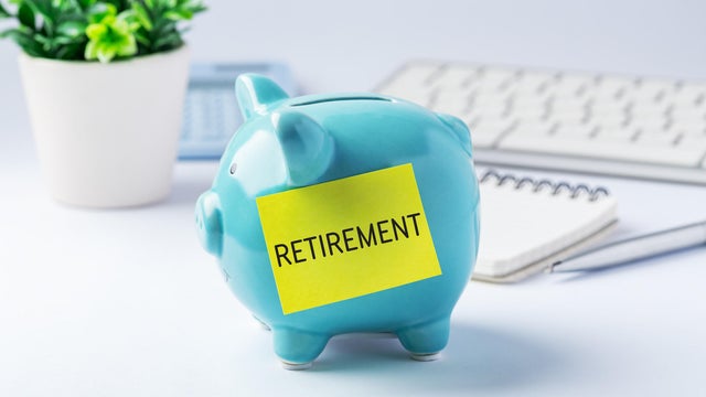 Retirement savings and investment concept with blue piggy bank and office supplies on work table 