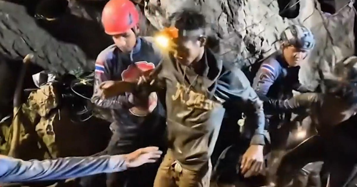 First rescued miner from cave emerges caked in mud after over a week underground