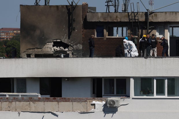 Law enforcement work on the site of an explosion at a residential block of flats following a drone hit in Galati 