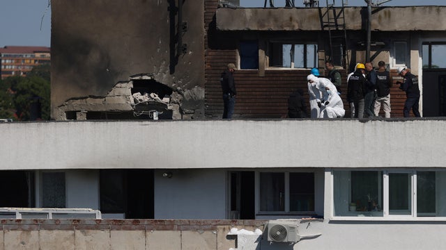 Law enforcement work on the site of an explosion at a residential block of flats following a drone hit in Galati 