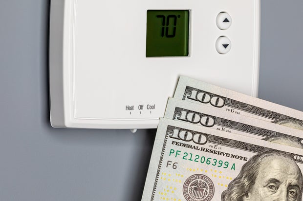 Thermostat for home furnace and air conditioner. Utility bill savings, energy cost and conservation concept 