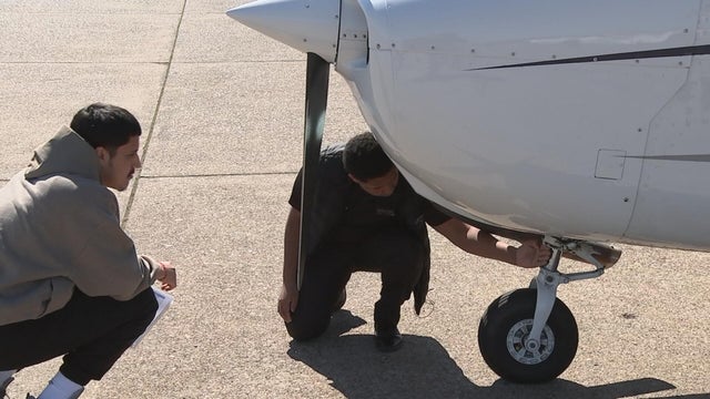 Jonathan Suarez (right) working on a plane with a fellow student 