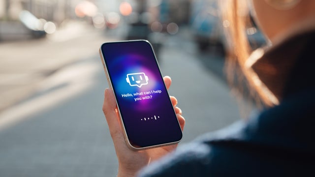 Young woman using AI chatbot mobile application on smartphone 