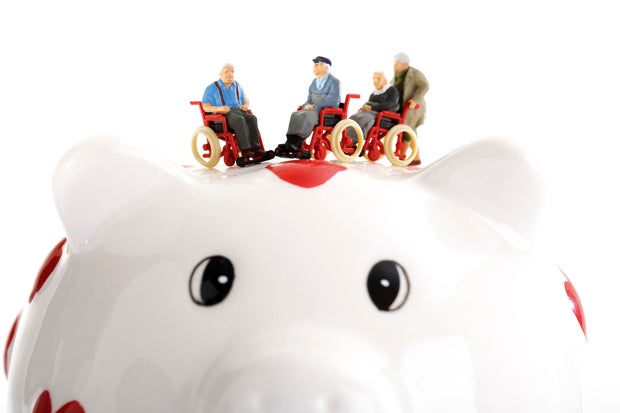 Figurine on wheelchairs on piggy bank