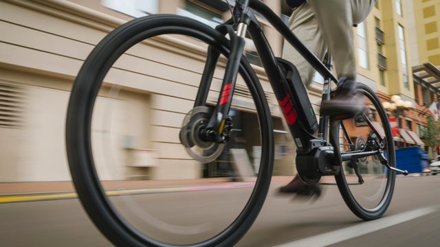 A professional man electric bicycle ebike commuting to work through the traffic of San Diego, California, USA 