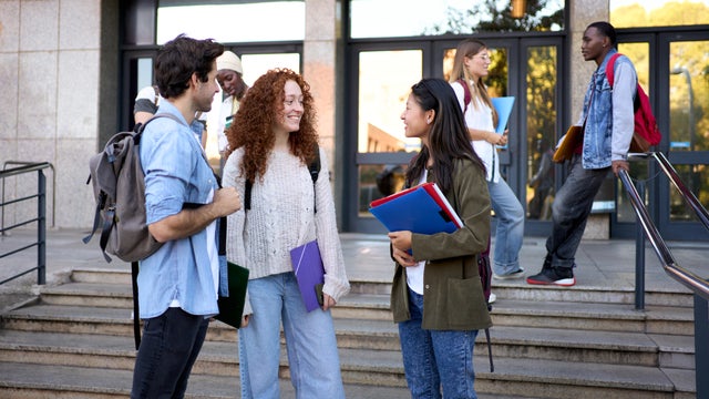 Group of students hanging out after class in the stairs of the high school building. 
