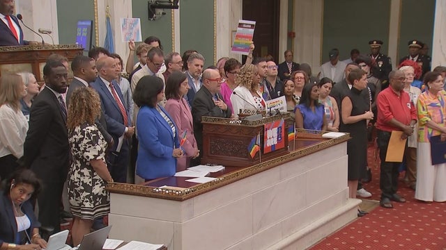 Mark Segal is surrounded by city leaders at a city council meeting 