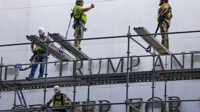 Workers stand on scaffolding outside the Kennedy Center on June 12, 2026, ahead of a deadline to remove President Trump's name from the building. 