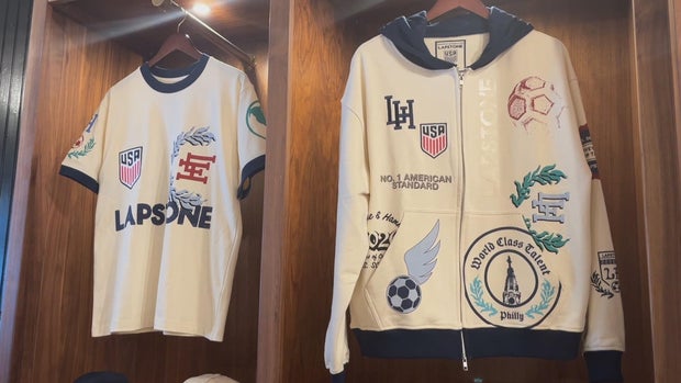 A short-sleeved shirt and a jacket from the collection hang in lockers