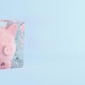 Pink piggy bank frozen in ice cube, frozen account concept, flat blue background, 3D Render 
