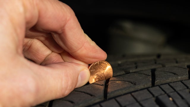 Checking tread depth on a tire by using a penny 