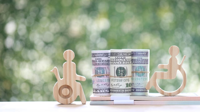 Man on wheelchair and banknotes on natural green background,Save money for prepare in future and handicapped person concept 