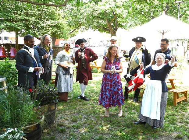 People pose for photos at City Tavern Garden 