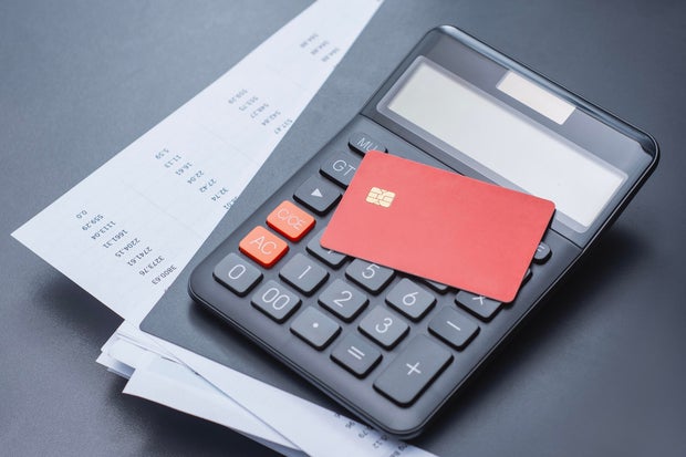 Red credit card with calculator and a payment schedule. Financial concept for credit card usage, loan calculations, monthly payment planning and interest rates. 