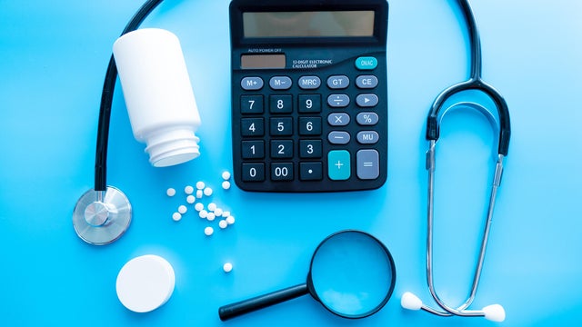 pills and medicines under a magnifying glass next to a medical stethoscope. The concept of health and responsible use of medicines, vitamins and various supplements 