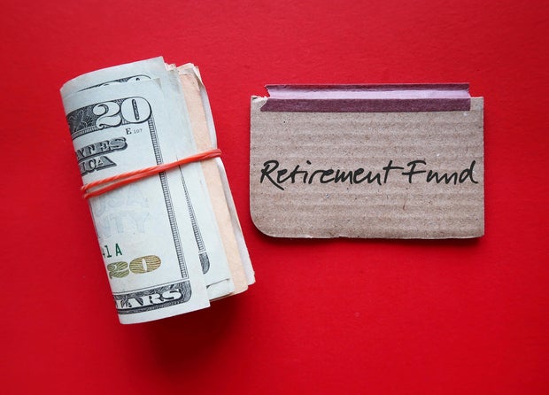 Dollars cash money and paper note with text written RETIREMENT FUND on copy space background - concept of financial planning saving money goal on purpose of retirement security