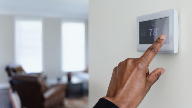 Woman Adjusts Thermostat 