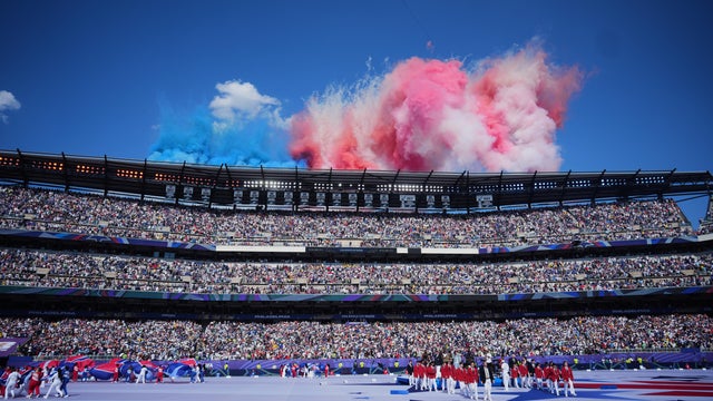 Red and white smoke from fireworks is seen over Philadelphia Stadium before the July 4 match between Paraguay and France 